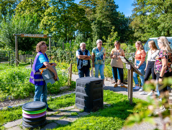 Gids geeft de tuintoer 'Ga voor groen' aan een groepje volwassenen in de tuin van het Duurzaamheidscentrum Assen