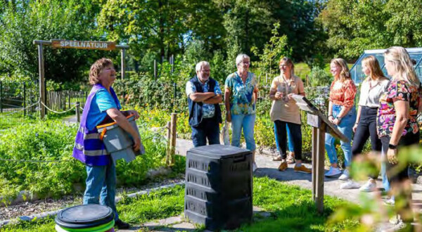 Vrijwilliger geeft tuintoer door de tuin van het Duurzaamheidscentrum Assen voor tips voor een groene tuin. Als je op de afbeelding klikt wordt hij vergroot.