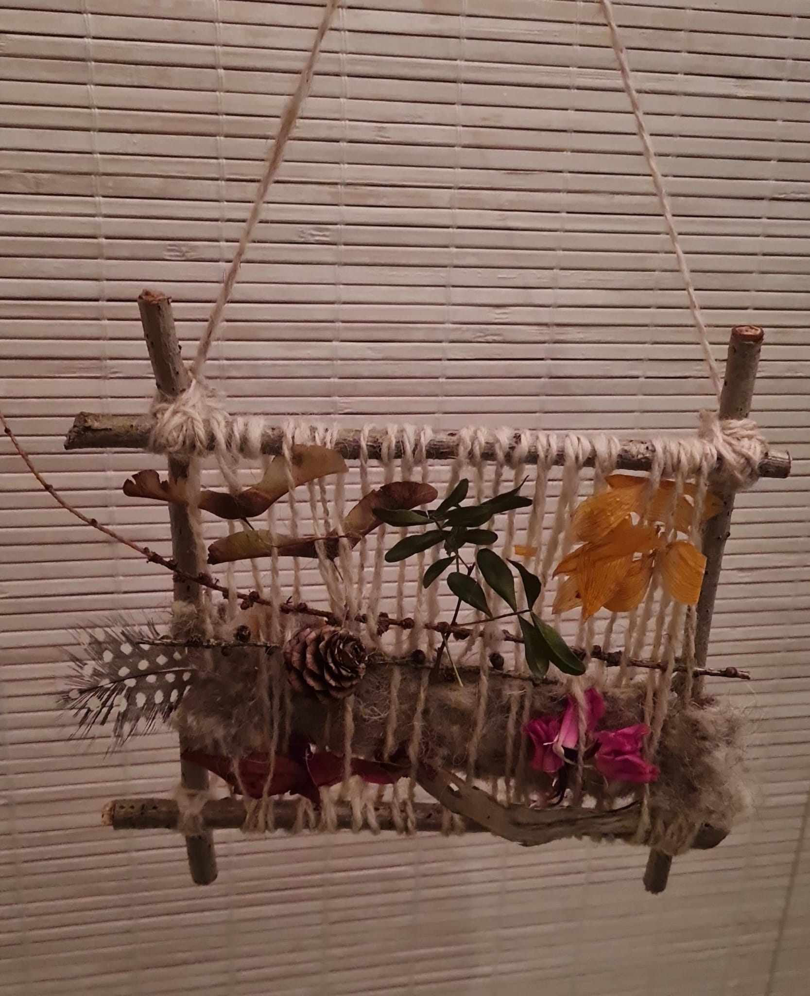 weefraampje met bladeren, bloemen, en wol